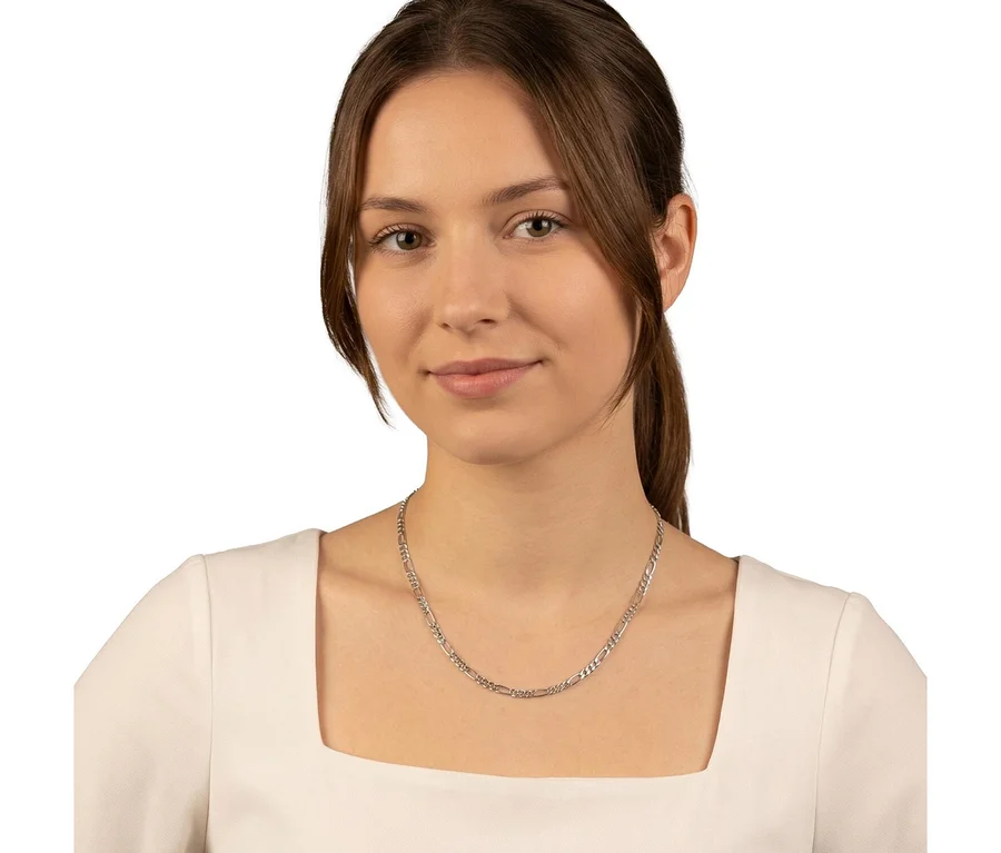 Junge Frau mit braunen Haaren trägt eine silberne Amor Figaro Halskette und blickt in die Kamera.