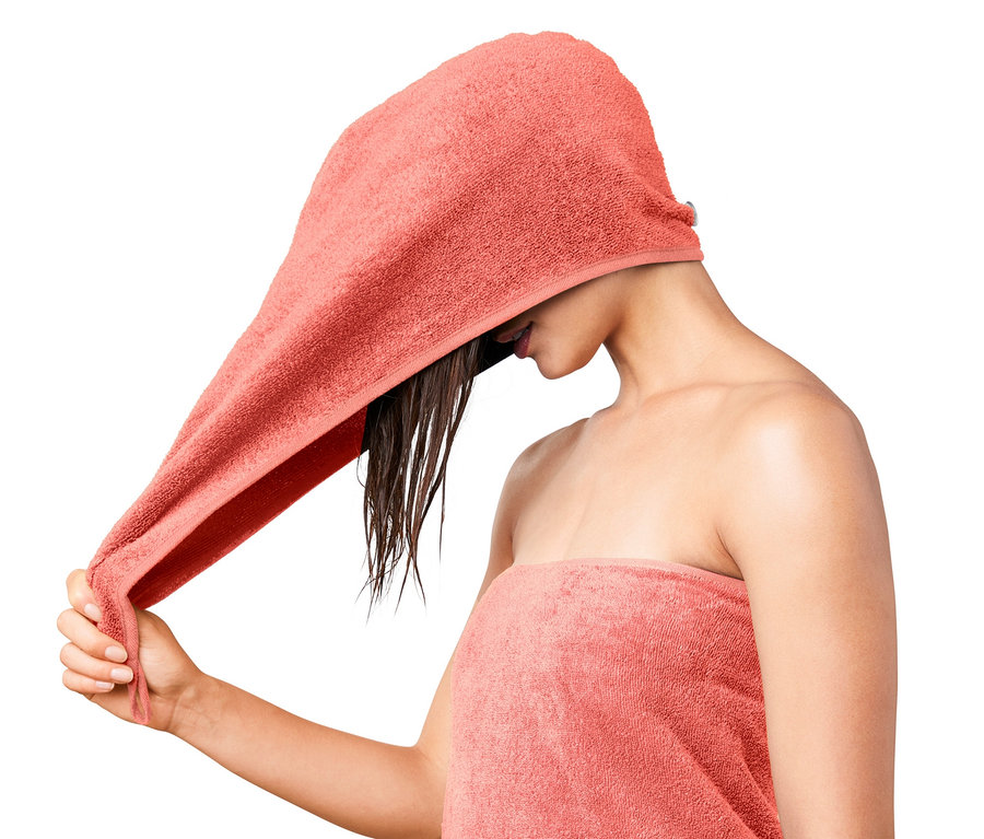 Frau wickelt ein Turban-Handtuch um ihre nassen Haare.