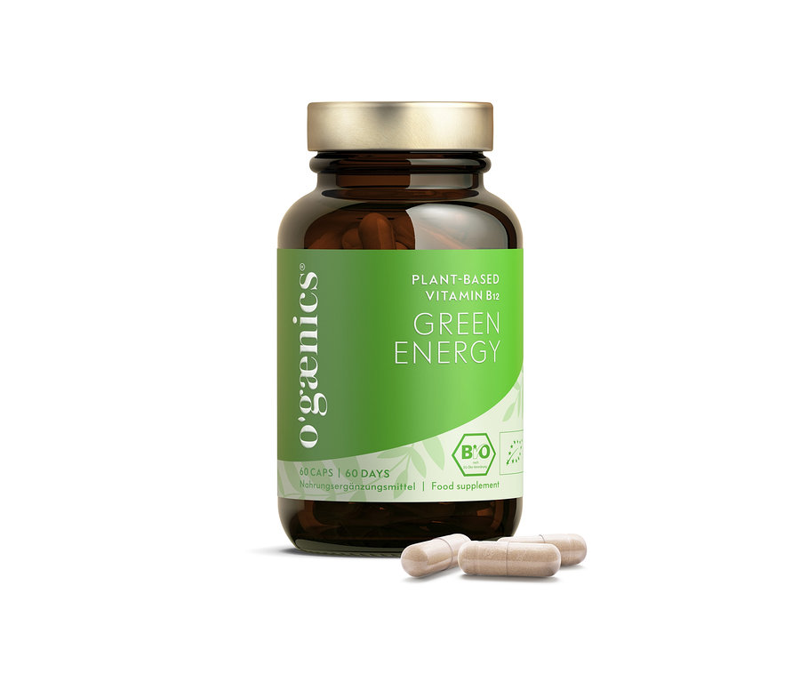 Braune Glasflasche mit Ogaenics Green Energy Plant-Based Vitamin B12 Nahrungsergänzungsmittel, davor liegen drei Kapseln.