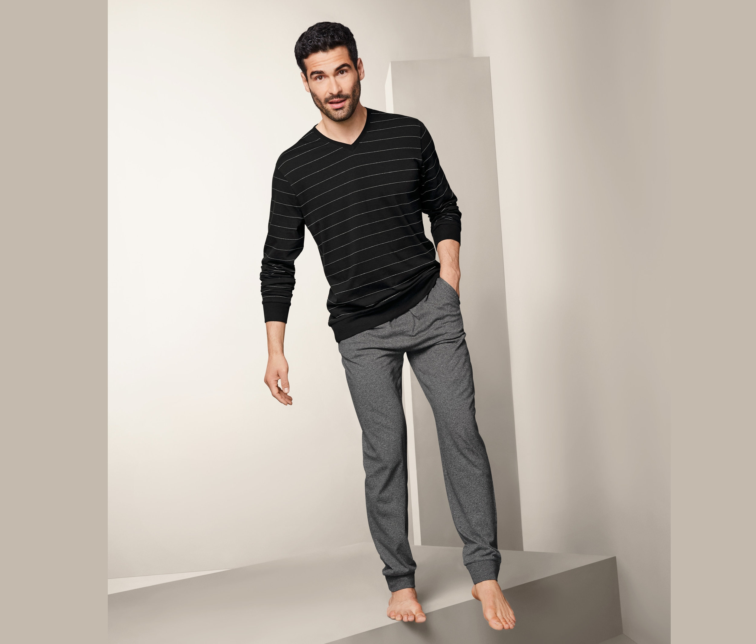 Mann im Pyjama steht auf Stufen.