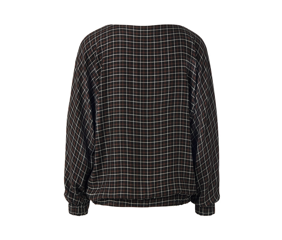 Detailaufnahme einer karierten Bluse mit Fledermausärmeln.