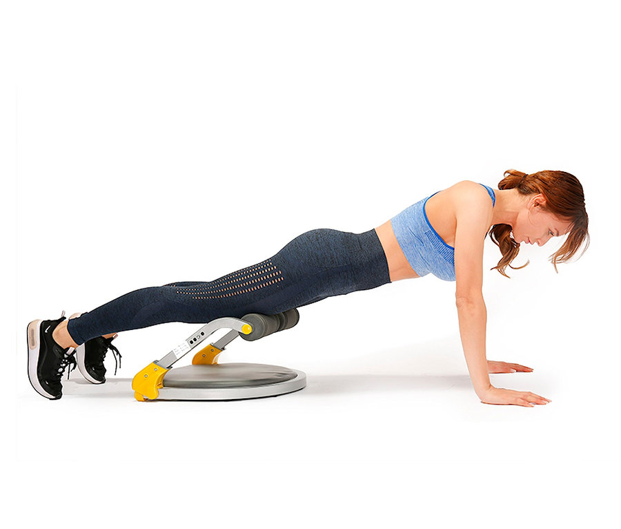 Frau macht Plank-Übung auf dem Body Coach Core Trimmer Fitnessgerät.