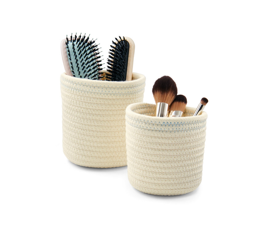 Zwei crèmeweiß-blaue Aufbewahrungskörbe, einer mit Haarbürsten, der andere mit Make-up-Pinseln.