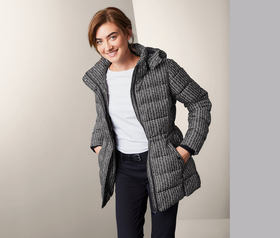 Frau posiert in Outdoorjacke mit Kapuze.