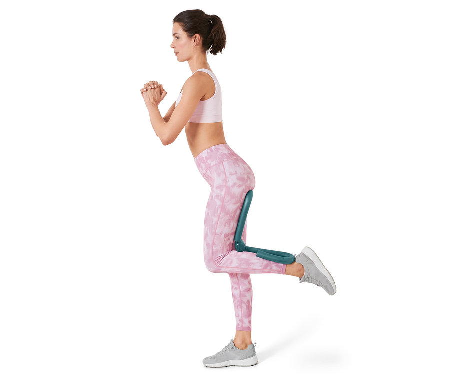 Frau trainiert Oberschenkel mit Arm-und-Bein-Trainer.