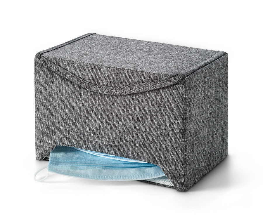 Graue Maskenbox mit einer blauen Maske, die aus einer Öffnung herausragt.