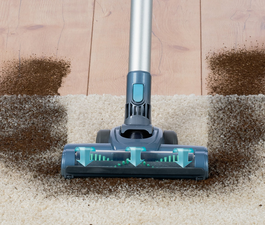 Ein Akku- Hand- und Bodenstaubsauger reinigt einen Teppich von Schmutz.