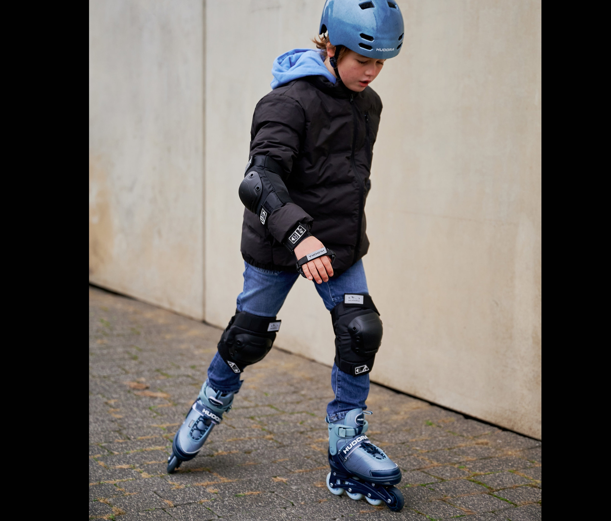Ein Junge fährt mit HUDORA Inline Skates »Leon 2.0« und Schützern.