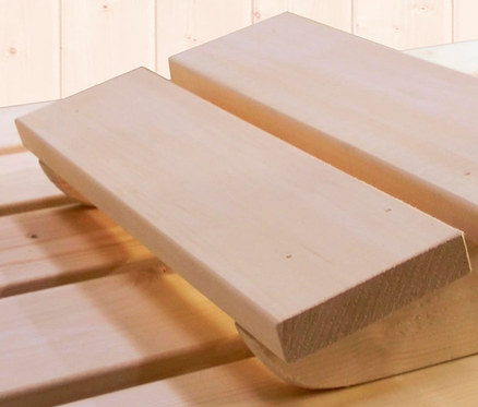 Ein hölzerner Fußhocker steht auf einem Holzboden.