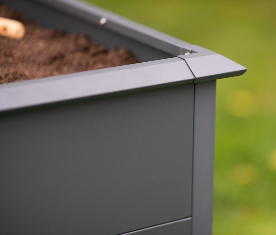 Detailaufnahme einer Ecke von einem Hochbeet mit Schneckenschutz, 200 cm, gefüllt mit Erde.