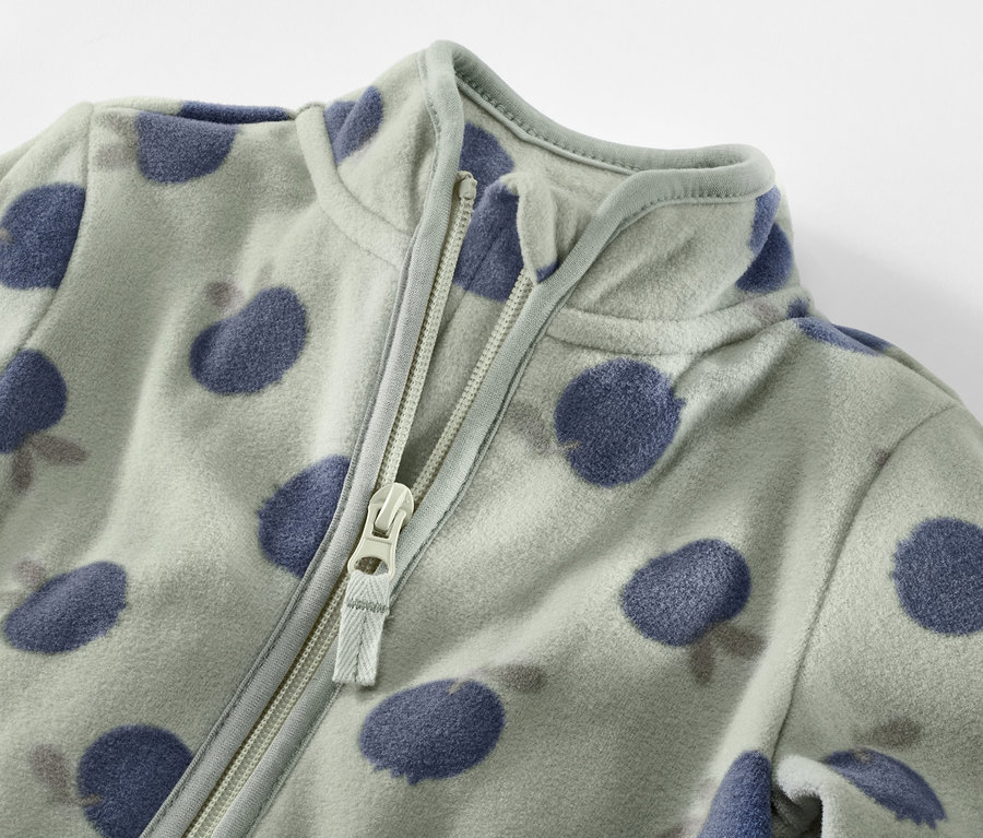 Detailaufnahme einer Kinder-Fleecejacke mit Blaubeermuster und Reißverschluss.