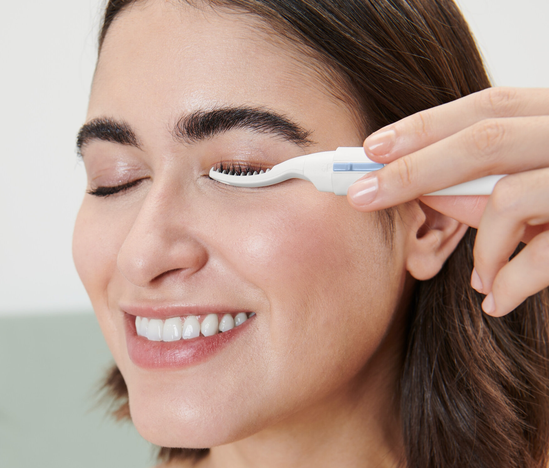 Frau verwendet einen beheizbaren Wimpernformer.