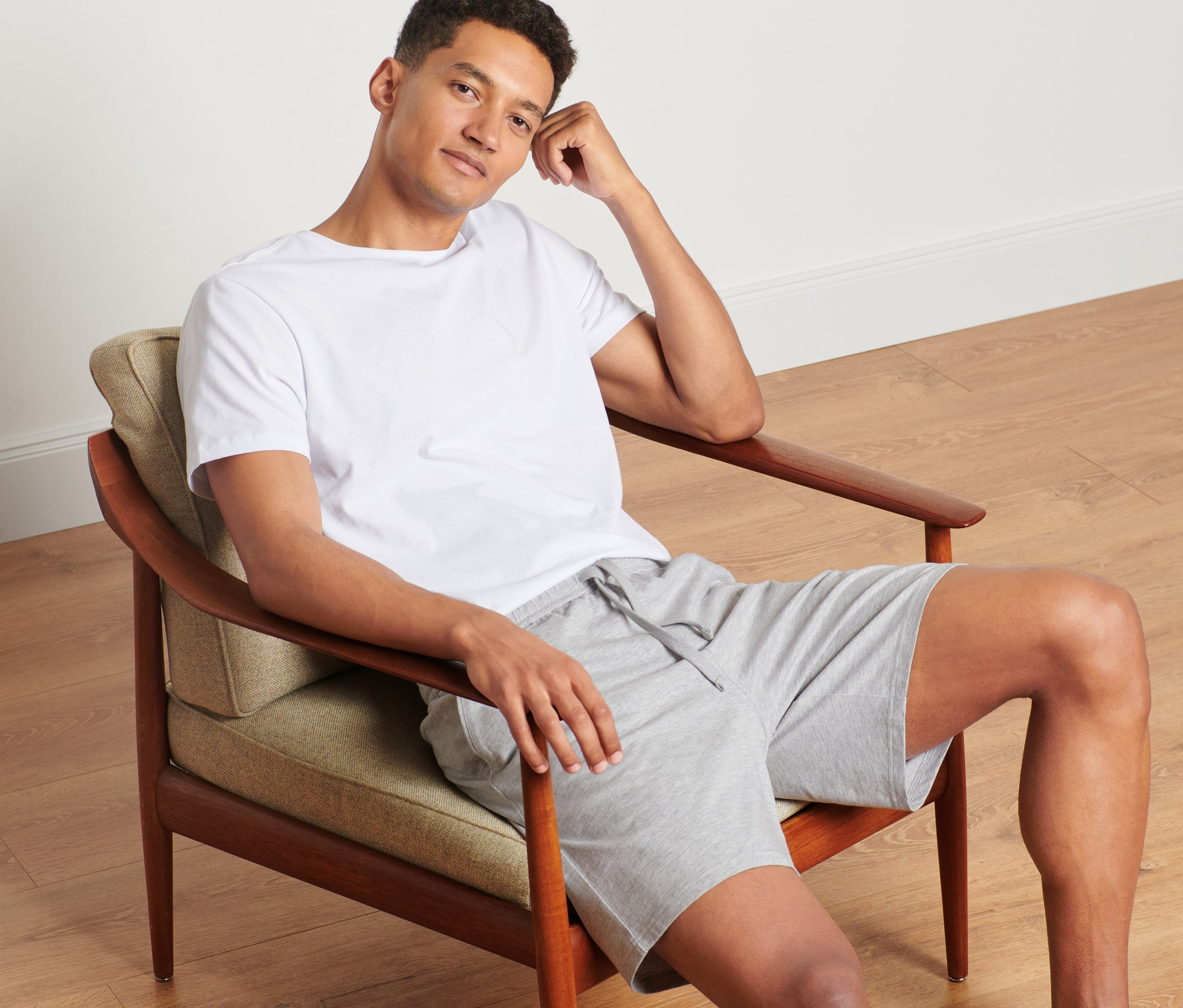 Mann sitzt im Sessel und trägt kurze Relaxhose.