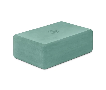 Ein grüner Yoga-Block auf einem weißen Hintergrund.