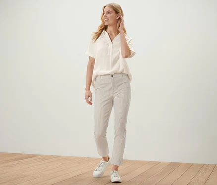 Frau posiert in hellblauer Bluse und einer gestreiften Stretch-Twill-Hose.