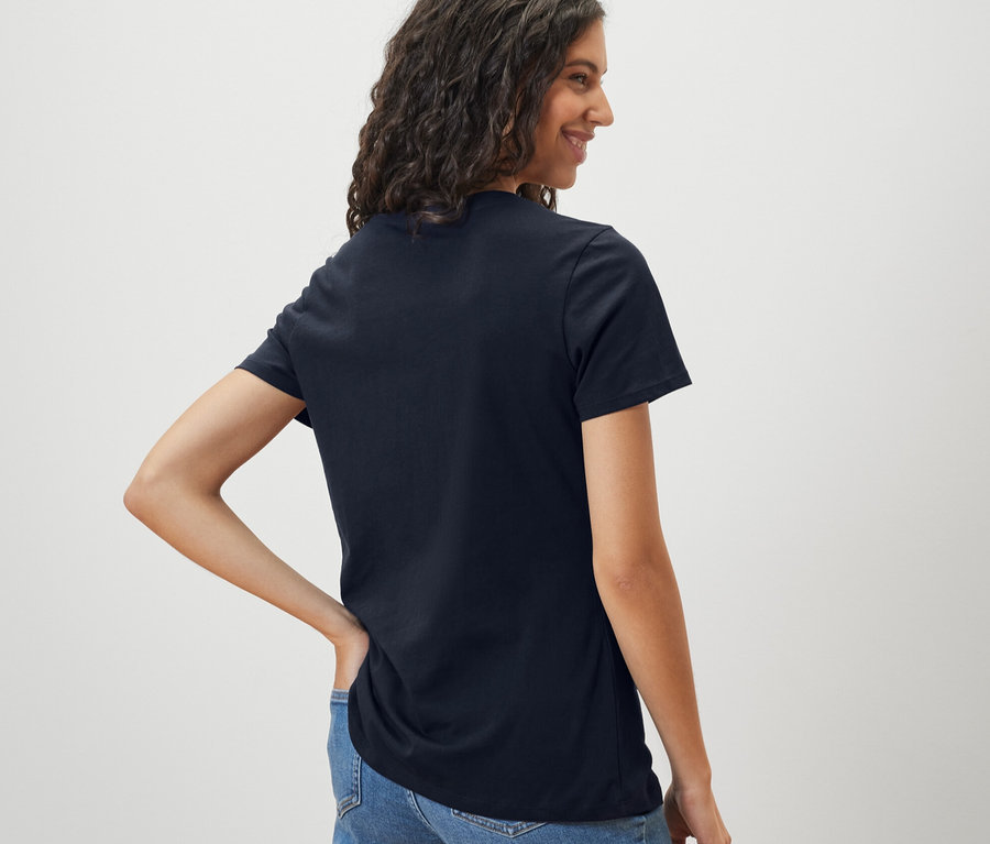 Frau trägt ein dunkelblaues Basic T-Shirt und Jeans.
