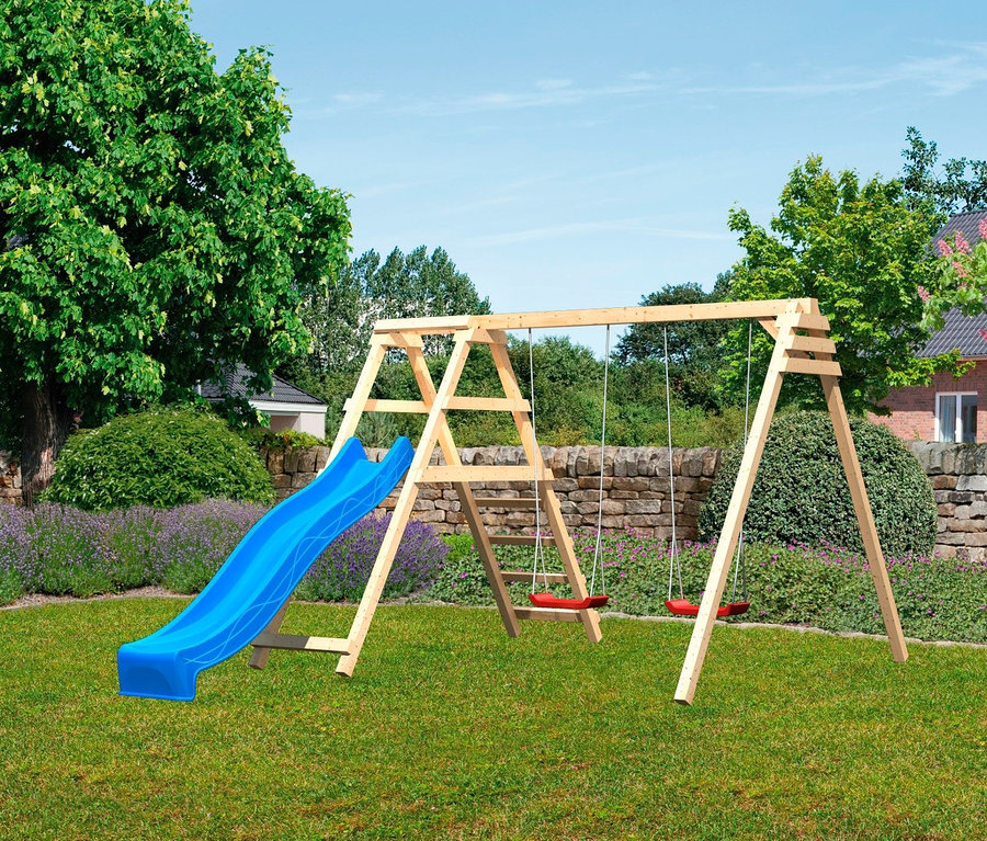 Eine Karibu Doppelschaukel »Felix« mit Klettergerüst und Rutsche steht auf einer grünen Wiese.