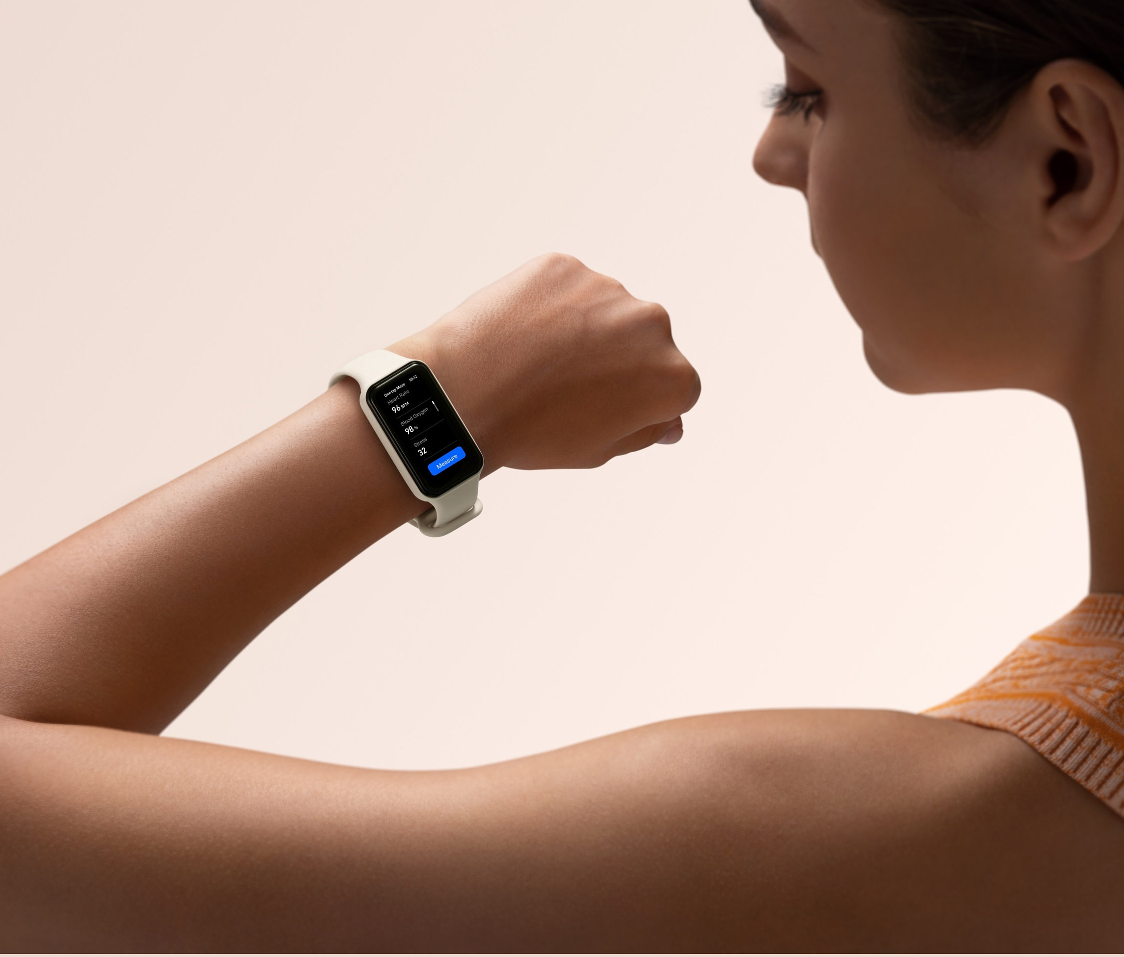 Frau schaut auf einen creme Amazfit Band 7 Aktivitätstracker auf ihrem Handgelenk.