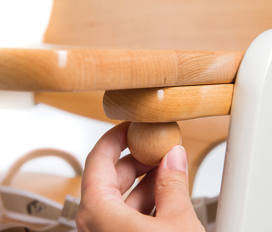 Eine Hand verstellt den hölzernen roba Treppenhochstuhl »Kid Up«.