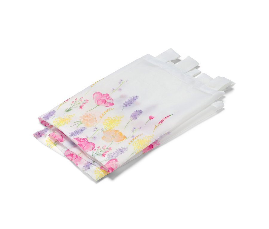 Gefaltete, bedruckte Bistrogardine mit Blumenmuster.