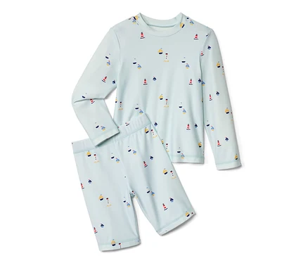 Helles Kinder-Kombi mit UV-Schutzfaktor 80, maritim: Langarmshirt und kurze Hose mit Leuchttürmen und Segelbooten.