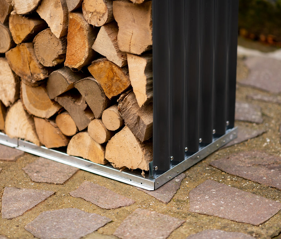 Detailaufnahme eines mit Holzscheiten gefüllten Kaminholzregals auf einem Steinboden.