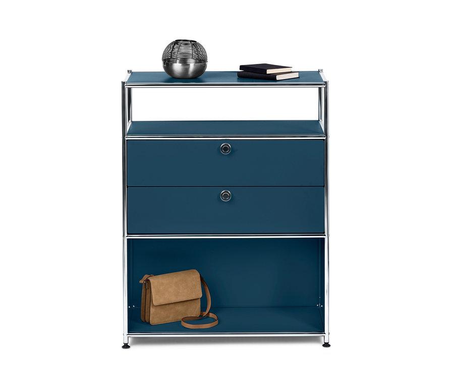 Blaues Sideboard »CN3« mit 2 Schubladen. Auf der obersten Ablage liegen eine silberne Dekokugel und zwei Bücher. Auf der untersten Ablage steht eine braune Handtasche.