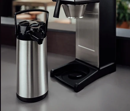 Eine silberne Bonamat Pumpthermoskanne 2,2 l neben einer professionellen Bravilor-Bonamat TH Filterkaffeemaschine ohne Kanne.