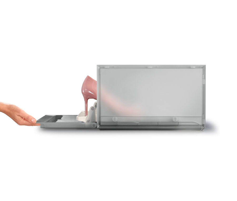 Eine Hand öffnet eine durchsichtige graue Joseph Joseph Premium-Schuhaufbewahrungsbox, in der sich ein rosa High Heel befindet.