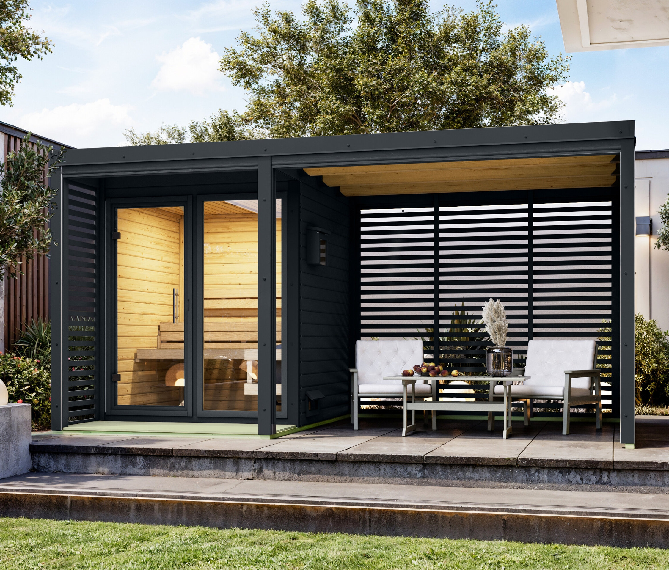 Außenansicht einer Sauna mit Sitzbereich mit zwei Stühlen und einem Tisch.