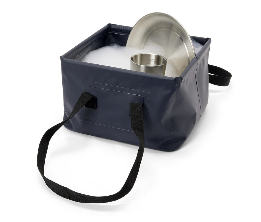 Edelstahlteller und -becher in faltbarer Spülschüssel mit Seifenwasser.