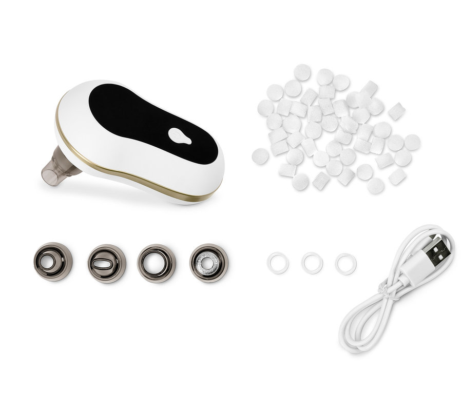 Porenreiniger mit Aufsätzen, USB-Kabel und weißen Schaumstoffpads.
