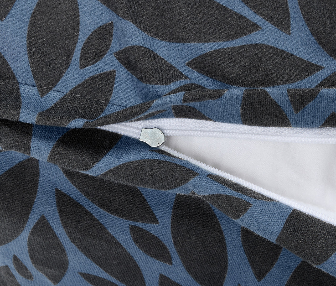 Detailaufnahme eines Reißverschlusses der dunkelblauen Winterjersey-Bettwäsche in Normalgröße mit Blattmuster.