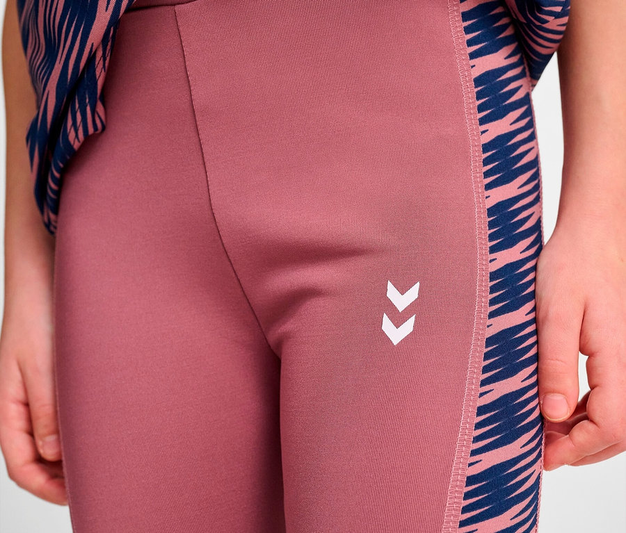 Detailaufnahme eines Mädchens in rosa Leggings mit blauen Streifen an der Seite und Logo.