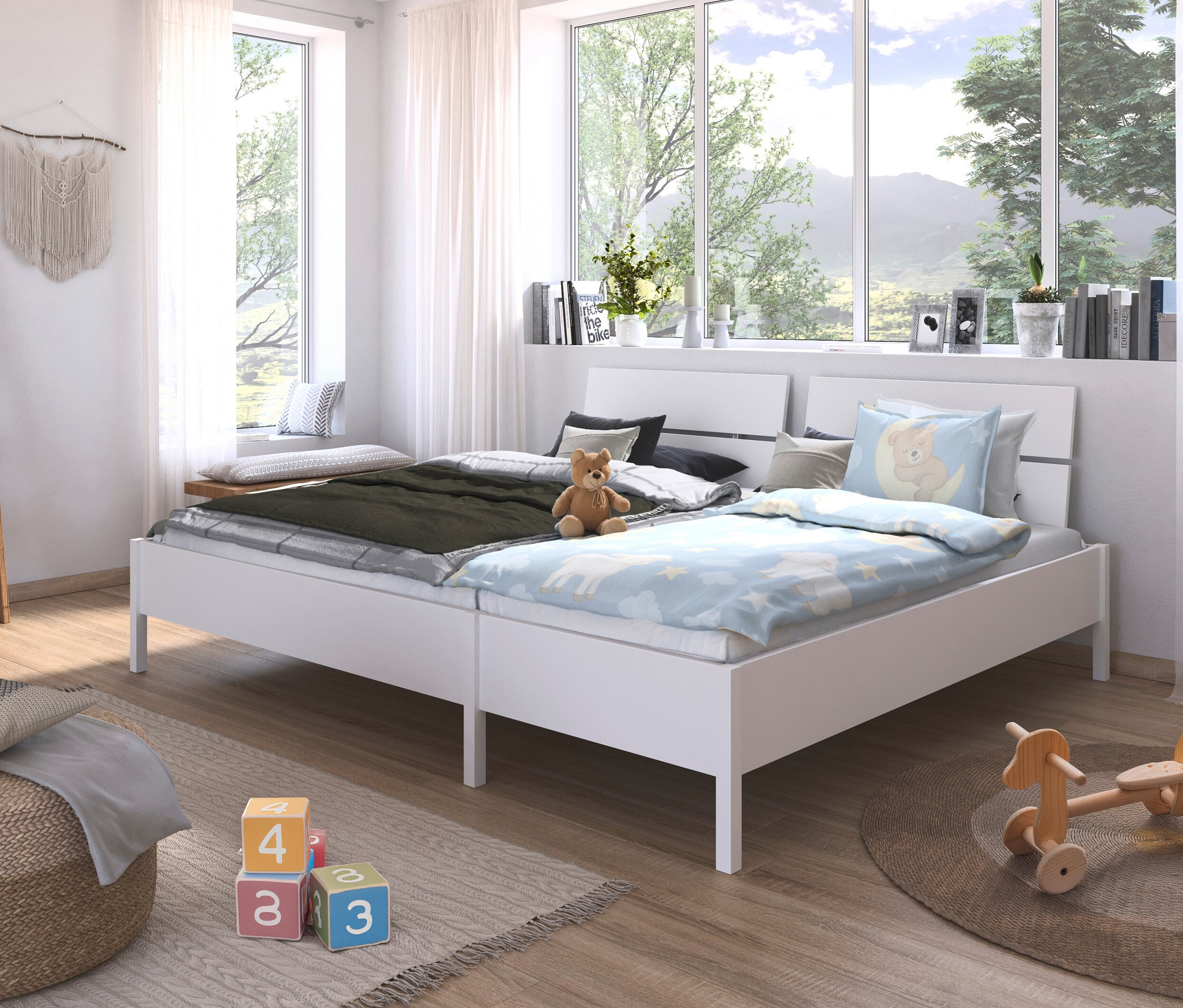 Zwei weiße Betten nebeneinander in einem Kinderzimmer, auf einem Bett liegt ein Teddybär.