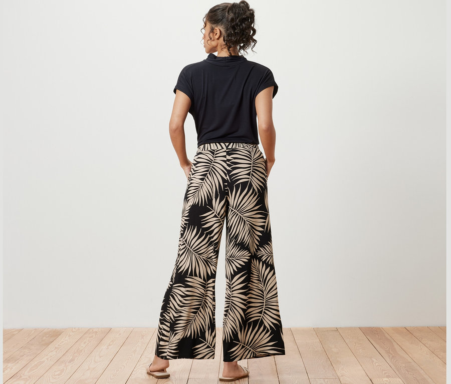 Frau posiert in bedruckter Palazzohose.