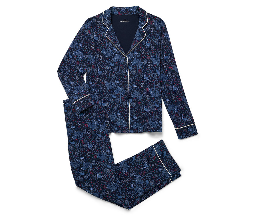 Ein marineblaues Pyjama-Set mit Alloverprint liegt gefaltet auf einem weißen Hintergrund.