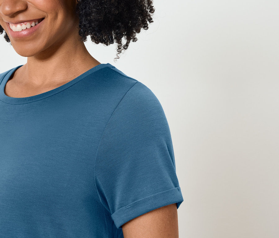 Lächelnde Frau trägt ein blaues T-Shirt.