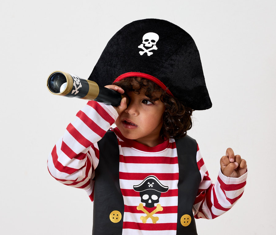 Junge im Piratenkostüm schaut durch ein Fernrohr.