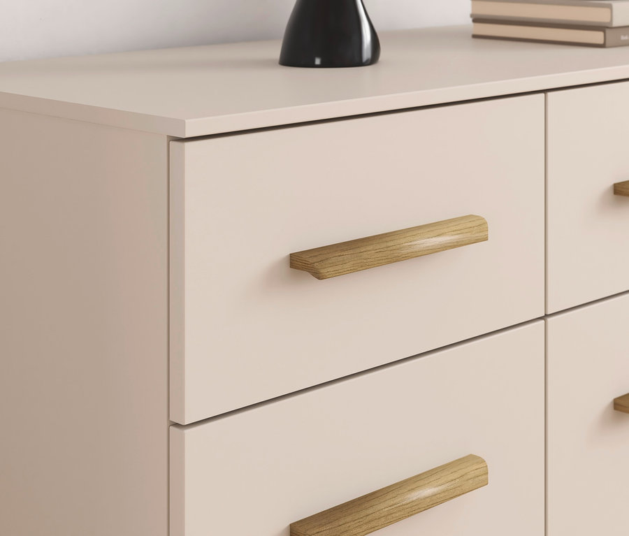 Detail einer Kommode mit vier Schubladen und Holzgriffen.