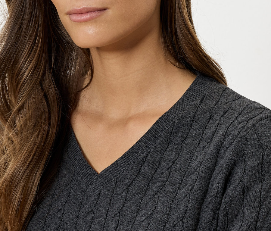 Detailaufnahme einer Frau, die einen grauen V-Ausschnitt-Zopfstrickpullover trägt.