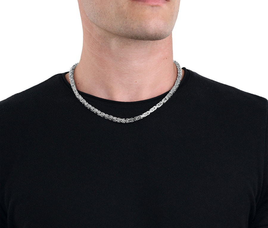 Mann trägt eine silberfarbene Halskette zu einem schwarzen T-Shirt.