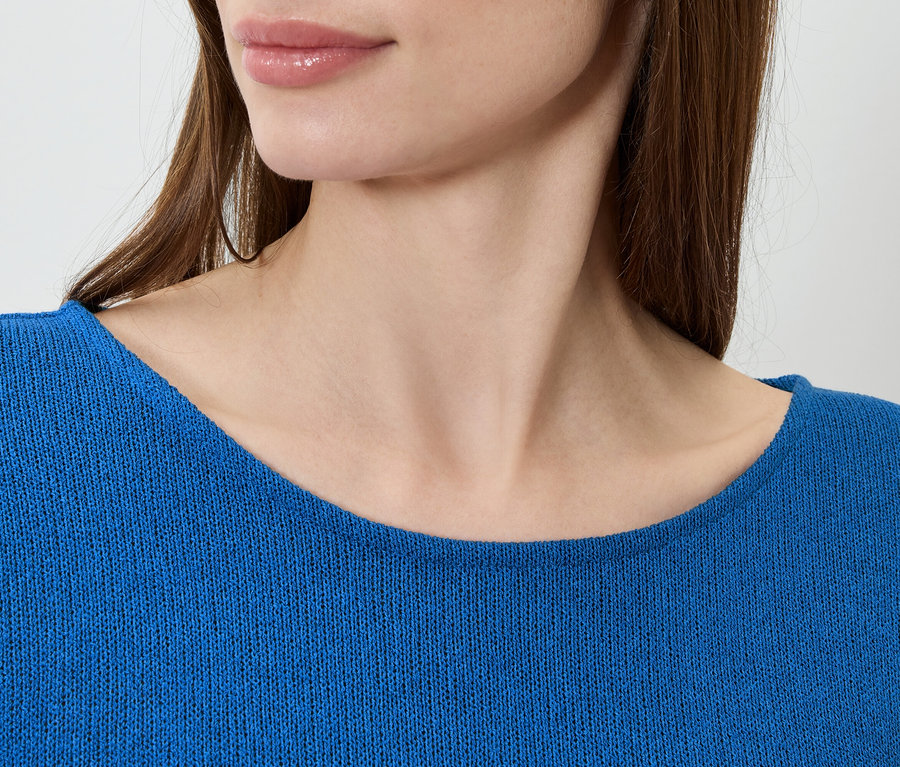 Nahaufnahme einer Frau, die einen blauen Pullover trägt.