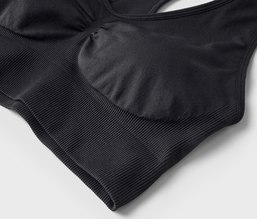 Nahaufnahme eines schwarzen Sport-BHs mit geripptem Unterbrustband und integrierten Cups.