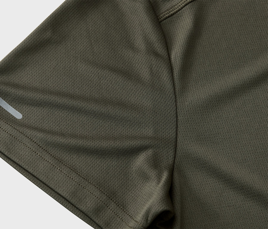 Nahaufnahme des Ärmels eines olivgrünen Sportshirts mit einem reflektierenden Streifen.