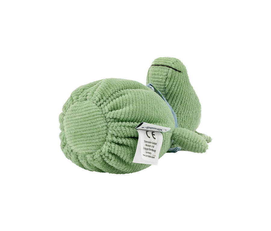 Hellgrünes Frosch-Stofftier aus Cord liegt auf der Seite, mit einem weißen Produktetikett an der Unterseite.