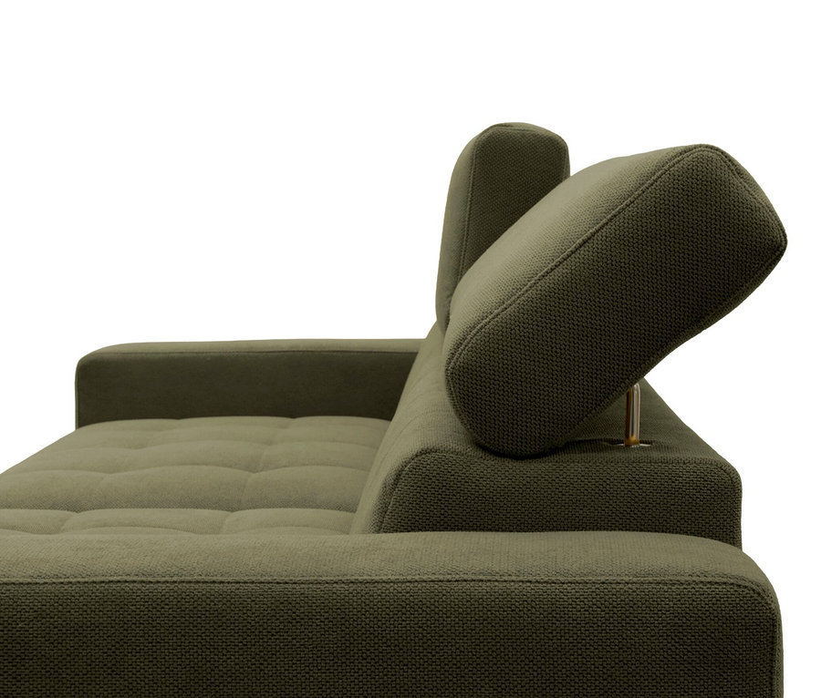 Nahaufnahme einer grünen Couch mit strukturierter Oberfläche, getufteter Sitzfläche und zwei verstellbaren Kopfstützen, eine aufrecht und eine geneigt.