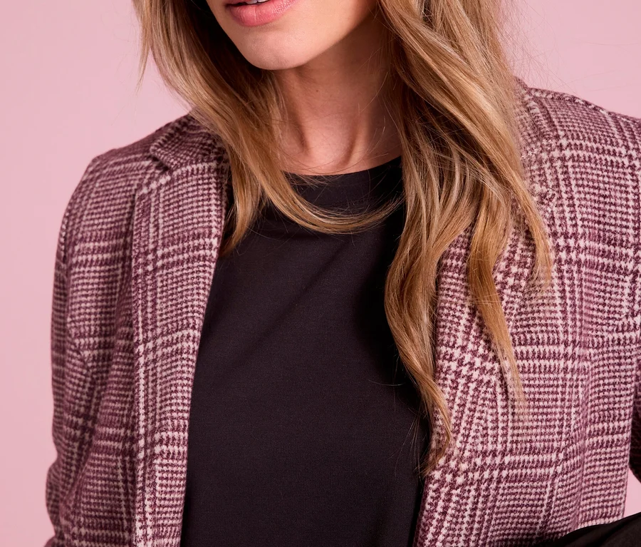 Nahaufnahme einer Frau mit blonden Haaren und blauen Augen, die einen karierten Street One Blazer über einem schwarzen Oberteil trägt.