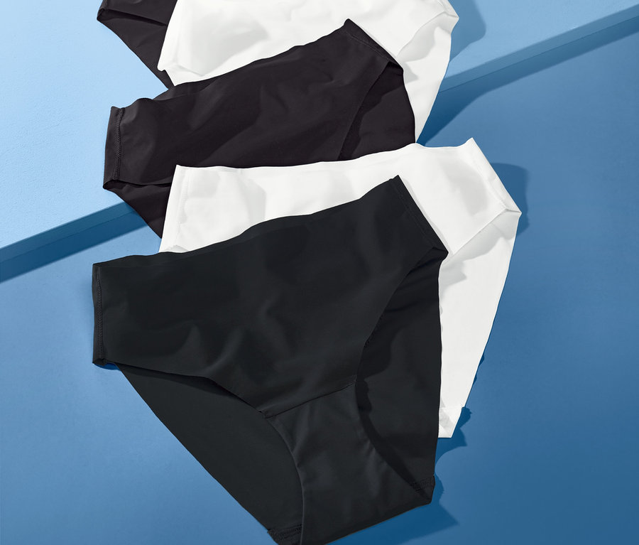 Fünf Magic-Cut-Slips in Schwarz und Weiß liegen auf blauem Hintergrund.