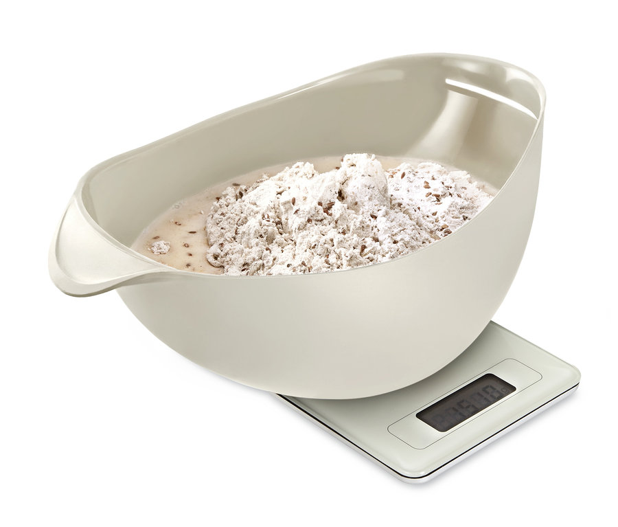Beige Brotbackschale mit Teig steht auf einer Digitalwaage.